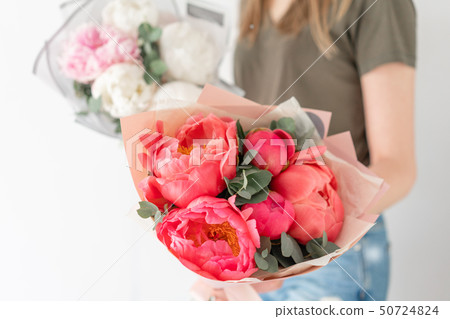 Two Beautiful bouquets. Coral and white peonies in womans hand. Beautiful peony flower for catalog 50724824