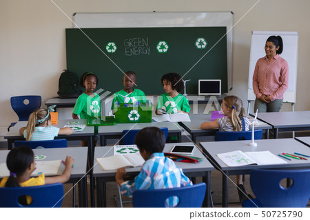 Schoolkids studying about green energy and recycle at desk in classroom Schoolkids studying about green energy and recycle at desk in classroom 50725790
