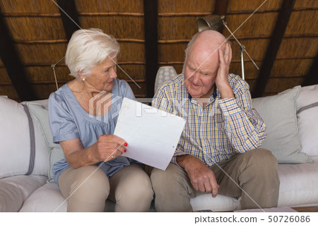 Worried senior couple discussing over medical bills Worried senior couple discussing over medical bills 50726086