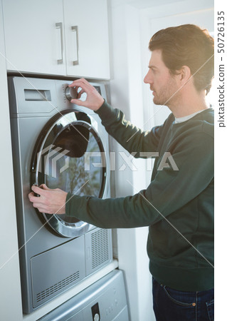 Man operating washing machine 50726135