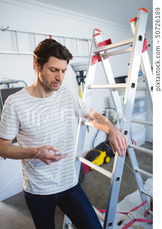 Male painter using mobile phone 50726189