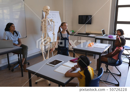Schoolkids studying in classroom 50726228