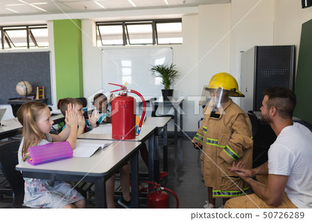 Side view of schoolkids applauding in classroom Side view of schoolkids applauding in classroom 50726289