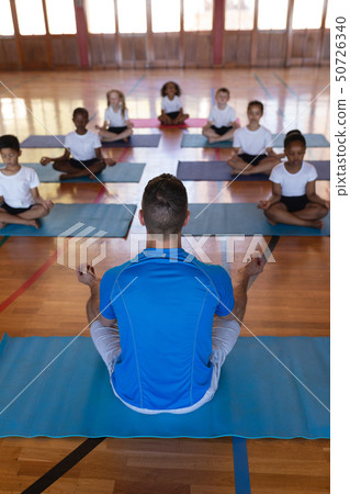 Yoga teacher teaching yoga to school kids in school Yoga teacher teaching yoga to school kids in school 50726340