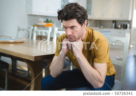 Worried man sitting at home Worried man sitting at home 50726341
