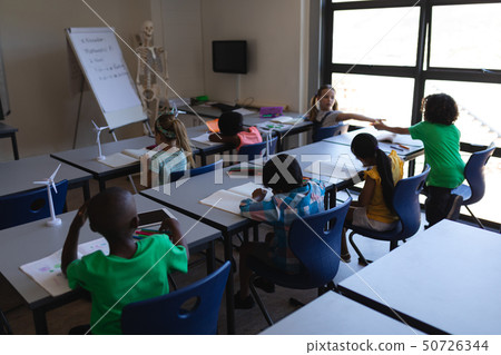 Schoolkids studying at desk in classroom Schoolkids studying at desk in classroom 50726344