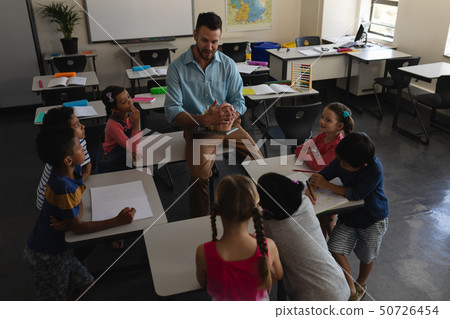 Male teacher teaching in classroom of elementary school 50726454