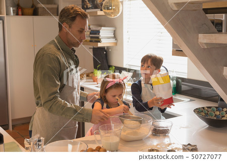 Father with his children preparing food in kitchen 50727077