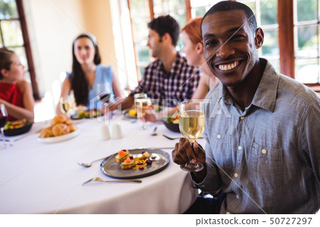 Man holding wine glass in restaurant Man holding wine glass in restaurant 50727297