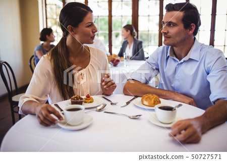 Couple talking with each other in restaurant Couple talking with each other in restaurant 50727571