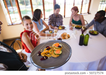 Waitress holding food on plate in restaurant Waitress holding food on plate in restaurant 50727574