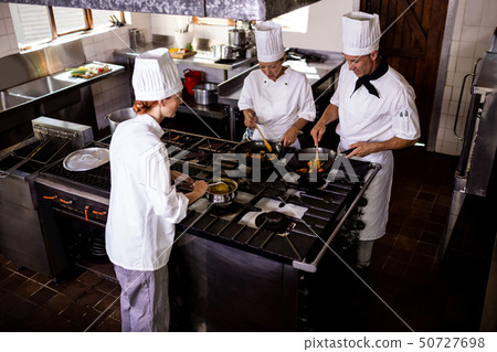 Group of chefs preparing food in kitchen 50727698