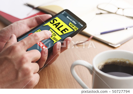 Up of male hand to see announcement of bargain sale with smartphone. Up of male hand to see announcement of bargain sale with smartphone. 50727794