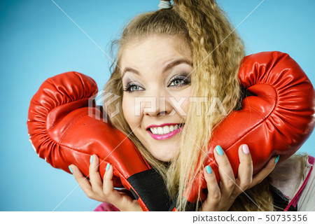 Funny girl in red gloves playing sports boxing 50735356