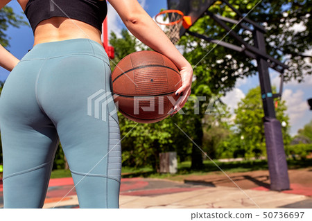 Beautiful sexy fitness girl in black sport wear with perfect body with basket ball at basketball 50736697