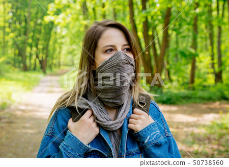 woman with backpack hide face with a scarf in forest woman with backpack hide face with a scarf in forest 50738560