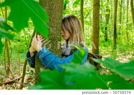 woman with backpack hugging a tree in forest woman with backpack hugging a tree in forest 50738574