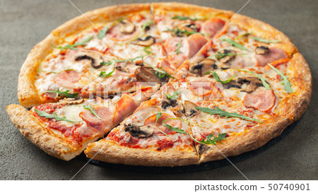 Delicious hot pizza with ham and champignons. 50740901