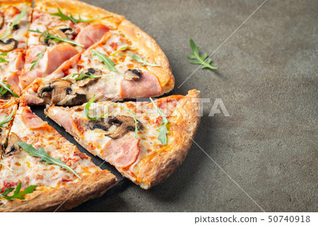 Delicious hot pizza with ham and champignons. 50740918