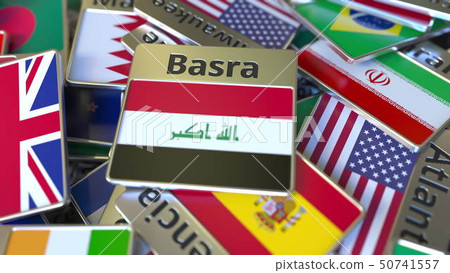 Souvenir magnet or badge with Basra text and national flag among different ones. Traveling to Iraq 50741557