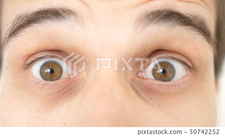 Close-up of a surprised emotional man with brown eyes Close-up of a surprised emotional man with brown eyes 50742252