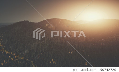 Sun beam mountainous wood peak slope aerial view 50742720