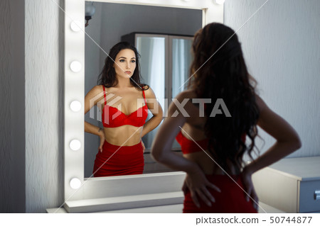 Beautiful young woman in a sexy red dress Beautiful young woman in a sexy red dress 50744877