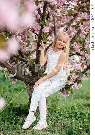 beautiful little child girl with sakura flowers 50745107