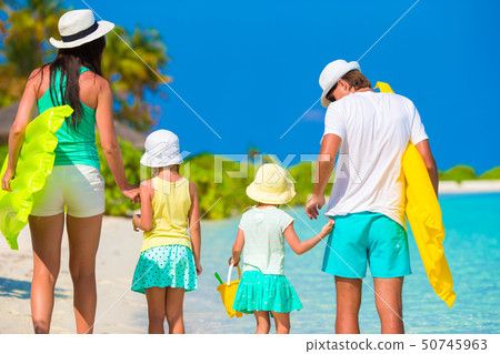 Happy family of four on white beach  50745963