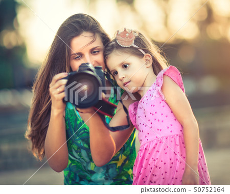 Mother and daughter taking photos with camera Mother and daughter taking photos with camera 50752164