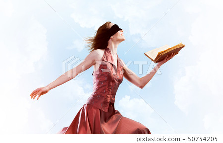 Girl against cloudy sky with opened book in palm as idea for knowledge Girl against cloudy sky with opened book in palm as idea for knowledge 50754205