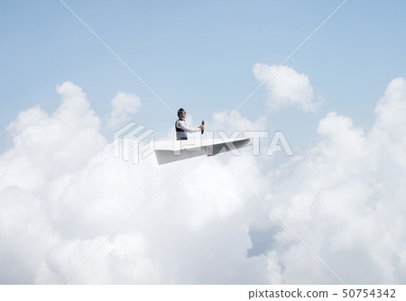 Businessman in aviator hat sitting in paper plane 50754342