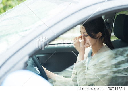 A woman driving a car 50755854