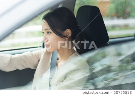 A woman driving a car 50755858