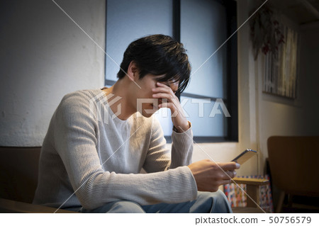 在手中認為巧妙的電話的人 在手中認為巧妙的電話的人 50756579