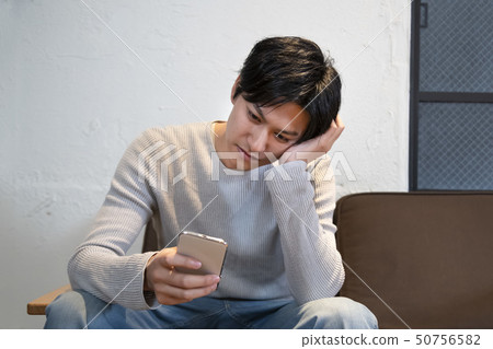 在手中認為巧妙的電話的人 50756582