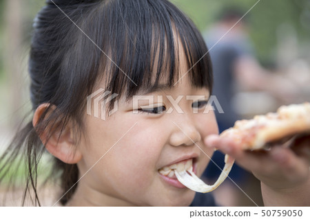 Girl eating homemade pizza outdoors Image outdoors 50759050