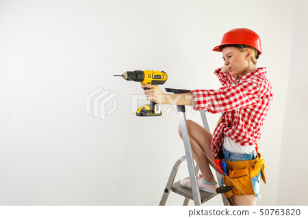 Woman having troubles using drill 50763820