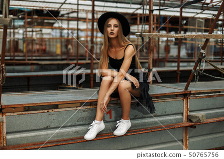 Beautiful young woman in a trendy black hat Beautiful young woman in a trendy black hat 50765756