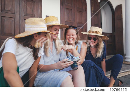 Group of happy joyful young stylish girls travel together, in hats against the 50766555
