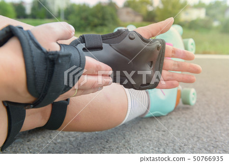 Woman rollerskater wearing wrist guards protector 50766935