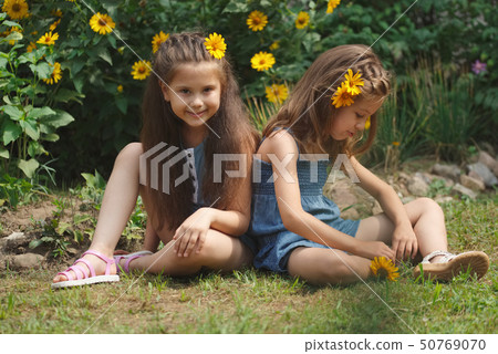 portrait of happy beautiful girls in flowerbed portrait of happy beautiful girls in flowerbed 50769070