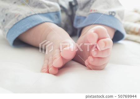 嬰兒的頭髮和腳趾在白色的被子上 嬰兒的頭髮和腳趾在白色的被子上 50769944