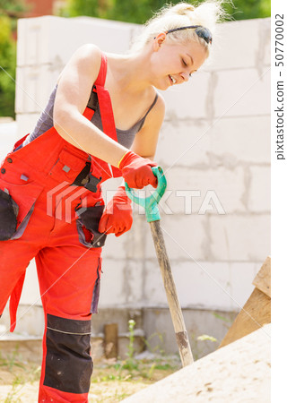 Woman using shovel on constriction site 50770002