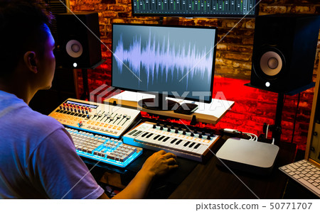 producer recording, editing music in home studio 50771707