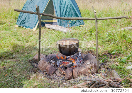 tourist kettle with the cooked food over the 50772704