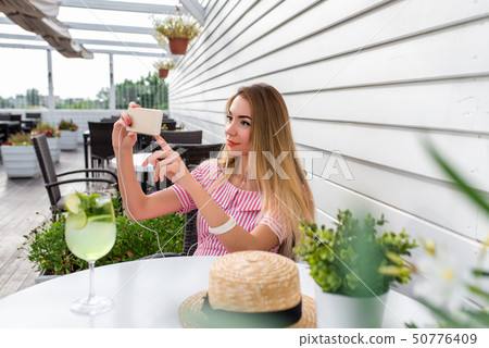 A woman cafe, having summer lunch breakfast, photographs telephone, online internet call. The 50776409