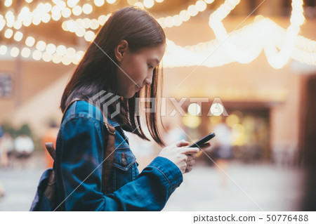 Teen girl using mobile phone to chat and send Teen girl using mobile phone to chat and send 50776488