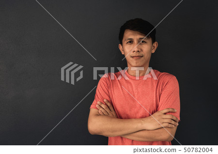 Asian guy in red blank t-shirt on black wall Asian guy in red blank t-shirt on black wall 50782004