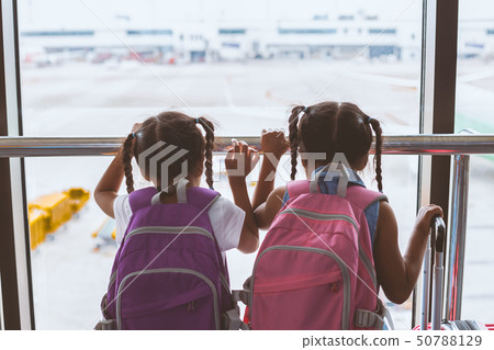 Two asian girl look at plane and wait for boarding Two asian girl look at plane and wait for boarding 50788129